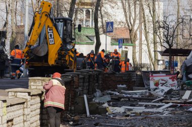 Kyiv, Ukrayna. 21 Mart 2024 sabahı erken saatlerde Ruslar şehre füze fırlattı. Hasarlı evler, arabalar ve yolda bir çukur. İnsanlar temizliğe yardım etmeye geldi..