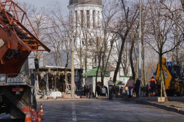 Kyiv, Ukrayna. 21 Mart 2024 sabahı erken saatlerde Ruslar şehre füze fırlattı. Hasarlı evler, arabalar ve yolda bir çukur. İnsanlar temizliğe yardım etmeye geldi..