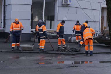 Kyiv, Ukrayna. 21 Mart 2024 sabahı erken saatlerde Ruslar şehre füze fırlattı. Hasarlı evler, arabalar ve yolda bir çukur. İnsanlar temizliğe yardım etmeye geldi..