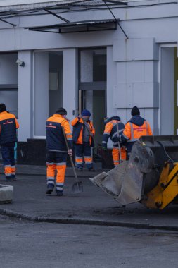 Kyiv, Ukrayna. 21 Mart 2024 sabahı erken saatlerde Ruslar şehre füze fırlattı. Hasarlı evler, arabalar ve yolda bir çukur. İnsanlar temizliğe yardım etmeye geldi..