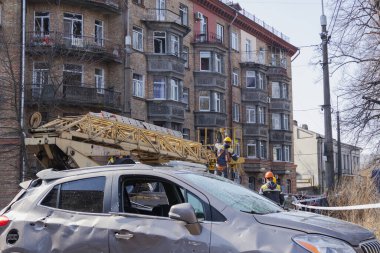 Kyiv, Ukrayna. 21 Mart 2024 sabahı erken saatlerde Ruslar şehre füze fırlattı. Hasarlı evler, arabalar ve yolda bir çukur. İnsanlar temizliğe yardım etmeye geldi..