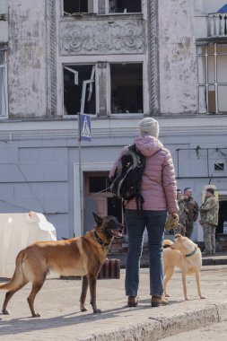 Kyiv, Ukrayna. 21 Mart 2024 sabahı erken saatlerde Ruslar şehre füze fırlattı. Hasarlı evler, arabalar ve yolda bir çukur. İnsanlar temizliğe yardım etmeye geldi..