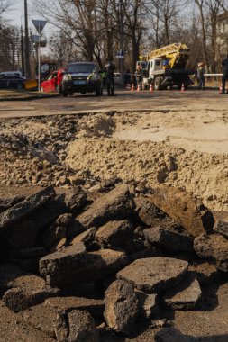 Kyiv, Ukrayna. 21 Mart 2024 sabahı erken saatlerde Ruslar şehre füze fırlattı. Roketler düşürüldü ama parçalar şehre düştü. Hasarlı evler ve yolda bir krater. Yaralılar var..