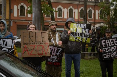 Kyiv, Ukrayna. 21 Nisan 2024 'te sağanak yağmur ve soğuk hava bile insanları durduramadı. Esir tutulan savaş esirlerine hatırlatmak ve desteklemek için bir kez daha şehrin merkezine gittiler.