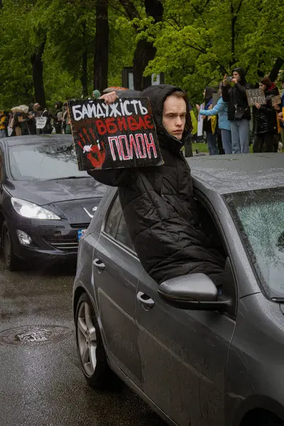 Kyiv, Ukrayna. 21 Nisan 2024 'te sağanak yağmur ve soğuk hava bile insanları durduramadı. Esir tutulan savaş esirlerine hatırlatmak ve desteklemek için bir kez daha şehrin merkezine gittiler.