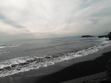 A beautiful beach located in Kamakura, Japan, with soft black sand. clipart