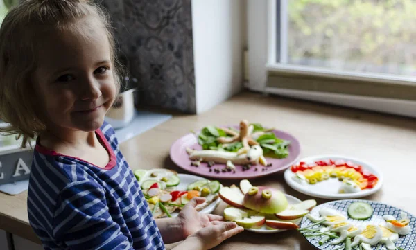 Lächelndes Kleines Mädchen Mit Buntem Essen Für Kinder Auf Einem — Stockfoto