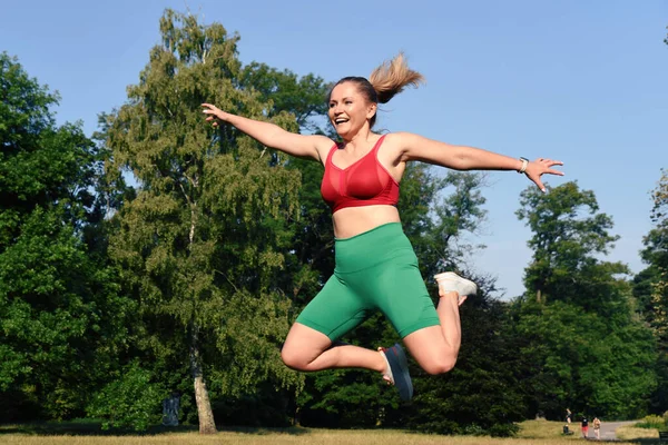 Sportswoman jump and fly during training and practice exercise. Energy, activity and strenght in sporty body. Happy woman in healthy lifestyle outdoor.