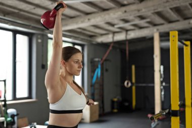 Spor salonunda spor salonunda halterle antrenman yapan kadın. Güçlü vücut ve çekici vücut için fiziksel egzersiz yapan aktif bir kız..