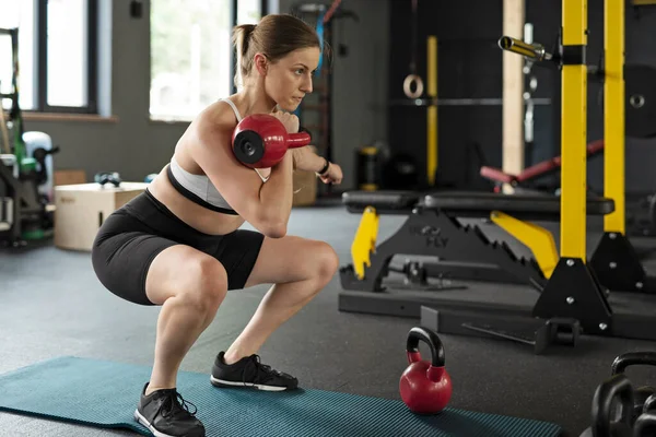 在一个有着沉重哑铃的运动队里 女运动员有力量和力量在室内训练身体和进行积极的体育锻炼 健康的生活方式和锻炼 — 图库照片