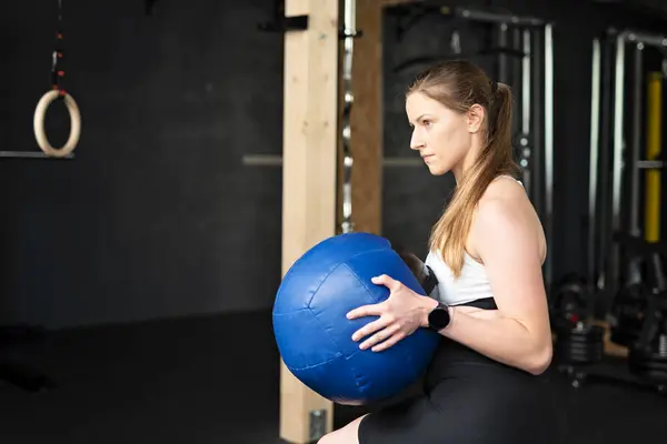 健身妇女手握医药球 进行功能性训练 室内体育馆的体育活动 — 图库照片