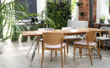 Çatı katında modern masa ve sandalyeler. Tuğla duvar ve dikey bahçe şık bir odada..