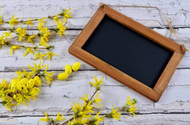 Paskalya yumurtalı, sarı çiçekli ve boş ahşap çerçeveli dilek kartı..