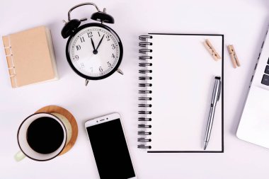 Boş defterli iş ve teknoloji ve model telefonlu telefon. Bir fincan kahve ve beyaz bir kitap kağıdıyla ofis masası. Düz nad üst görünüm yatıyordu.