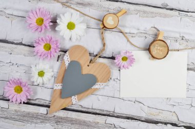 Tahta arka planda beyaz, kalp ve pembe çiçeklerle anneler günü için tebrik kartı. Tatil.