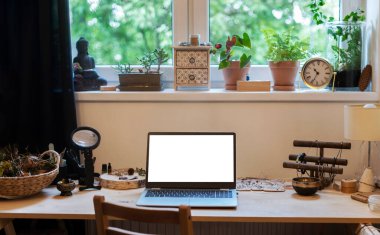 Boş ekranlı dizüstü bilgisayarlı ofis masası. İşten eve gelirken penceresi olan rahat bir oda.