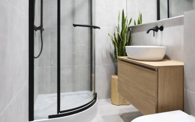 Gri fayanslı modern banyo, ahşap mobilyalar, duş, şık lavabo ve ayna. Endüstriyel iç mekanlar.