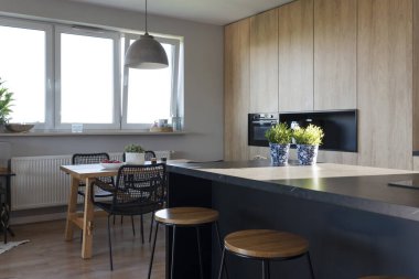 Ahşap yemek masası olan, mermer ve camdan yapılma bir mutfak. Yemek odası, ahşap dolap ve mobilyalar..