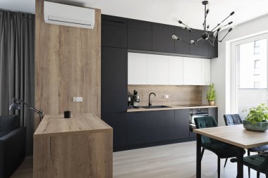 Modern kitchen interior with stylish furniture with wooden counter, window, table and chairs in contemporary style. Architecture interior design in new apartment.