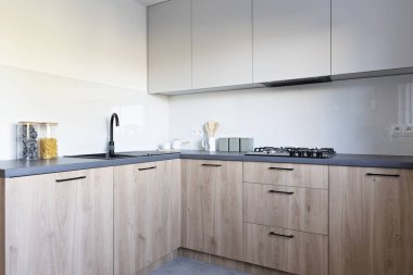 Modern mutfak içi ahşap mobilyalar, fırın tezgahta lavabo ve duvarda boş çerçeve. Şık tasarımı olan yeni bir daire