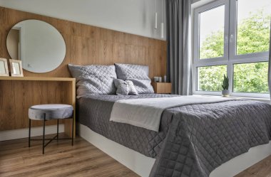Rahat çift kişilik yatak, gri yastıklar, beyaz yatak örtüsü ve rahat yatak odası. Otelin içinde, duvarında çerçeve olan şık bir yer. Evdeki modern oda..