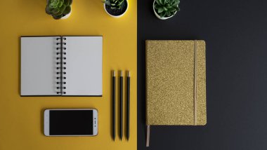 Siyah ekranlı, klavyeli, not defterli ve kahveli modern siyah ve sarı ofis masası. Kopyalama alanı olan üst görünüm, düz yatay.