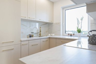 Modern mutfak iç mimarisi lüks mobilyalar, mutfak lavabosu ve duvarında mermer kaplama olan altın musluk. Kapalı alan mimarisi tasarımı.