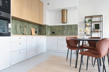 Yemek masası, sandalye ve duvarında fayanslar olan modern tasarım mutfağı. Yeni dairede ev dekorasyonu.