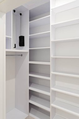 Beyaz ahşaptan yapılmış modern kapalı dolap. Evde boş dolaplar var. Apartmanda ahşap mobilyalar. Dikey.