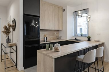 Yemek masası, sandalye ve ahşap tezgahlı modern mutfak. Pencereli tasarım evinde modern ve şık mobilyalar. Kapalı mekan mimarisi. Emlak.