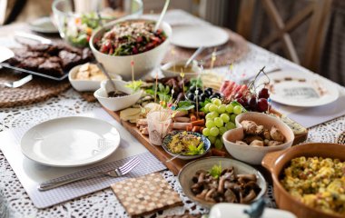 Öğle yemeği ya da kahvaltıda masada yemek için taze yiyecek. Soğuk tabak salata, peynir, jambon, üzüm ve zeytin. Evde peçeteyle hazırlanmış ev yapımı yemek. Pankart.