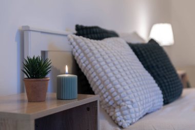 Yatak odasının içinde rahat bir yatak odası, yastıklı ve mumlu. Modern kapalı bir otel odası..