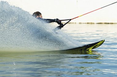 Su püskürten bir bulutun içindeki hızlı wakeboardçu.