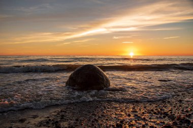 Gün batımının, plajın, denizin, taşın, dalganın manzara fotoğrafçılığı