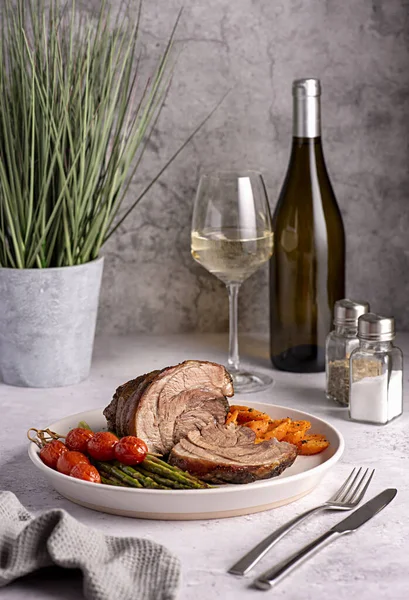 ロースト子羊 ニンジン アスパラガス トマト 白ワイン ボトル ワイングラスの食品写真 — ストック写真