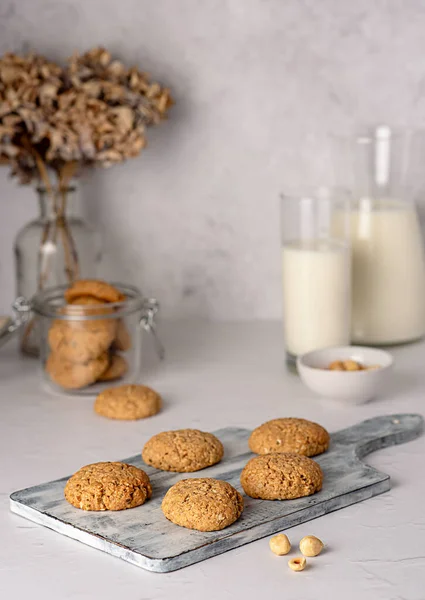 Food photography of oat biscuit; oatmeal; cookie;nut; hazelnut, pastry, dessert;jar, glass, board