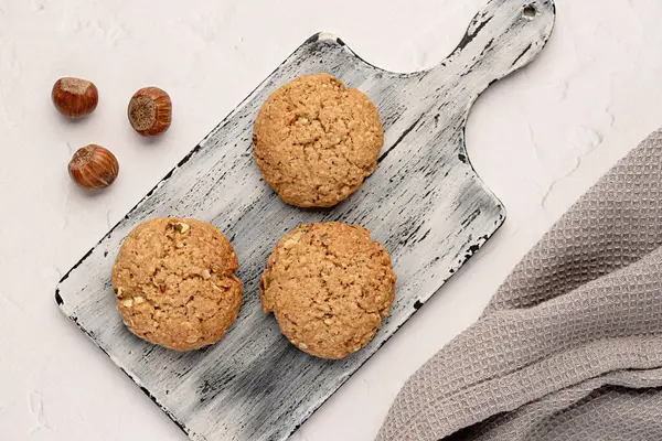 Food photography of oat biscuit; oatmeal; cookie;nut; hazelnut, pastry, dessert; wooden board