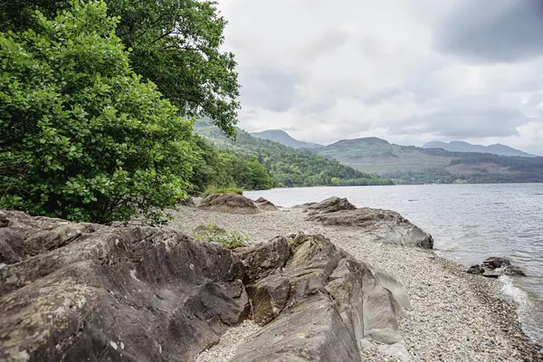 stock image Landscape photography of lake shore, tree, boulder; rock, stone; rocky, reflection, nature; national park, landscape, serenity; scenery; panorama; water, reservoir, scotland, loch lomond