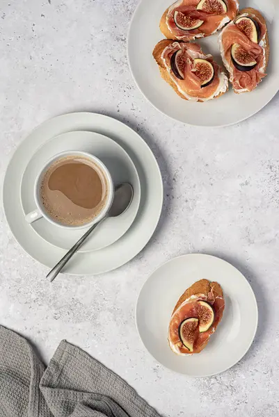 Bruschetta 'nın yemek fotoğrafı, yumuşak peynirli tost, jambon ve incir, kahve kapuçino, sütlü çay, kahvaltı, arka plan.