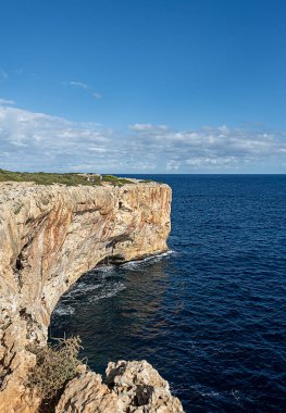 Kaya tırmanışı, kayalık sahil manzarası; turizm beldesi; bulutlu mavi gökyüzü, kayalar; kayalar; Mallorca; İspanya; Porto Cristo del Diablo