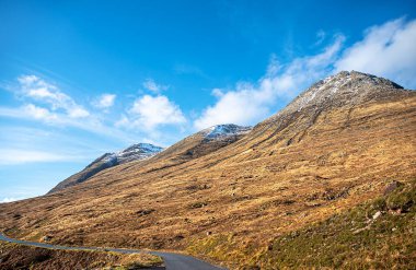 Glen Etive Road, Glencoe, İskoçya, İngiltere, dağlar, kış koşulları, dağın zirvesinde kar, yürüyüş, vadi, kayalık tepe, ay ve mavi gökyüzü,