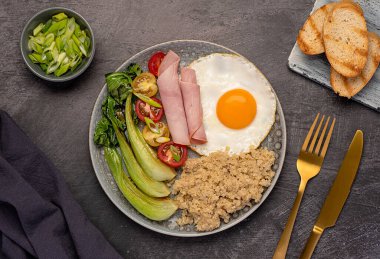 Dengeli kahvaltı fotoğrafları, kinoalı sahanda yumurta, choy, jambon, domates, taze soğan, tost, diyet lifleri, sağlıklı yiyecekler.