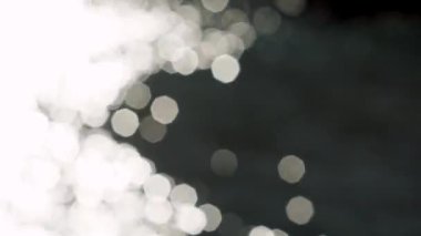 Big solar bunnies in the form of octagons. Blurred sparkling defocused light on water surface. 