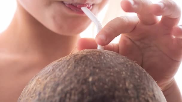 금발의한 소녀는 코코넛에서 나오는 코코넛물을 빨대를 마신다 클로즈업 — 비디오