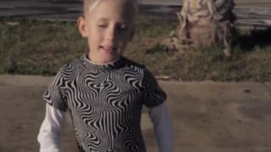 Saçları örgülü sarışın kız etrafta dans ediyor. Yavaş çekim