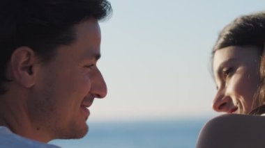 Genç ve güzel bir kadın sahilde genç bir adamla konuşuyor. Çiftler köpeklerle oynarken eğleniyor. Yakın plan.