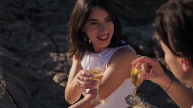 Beyaz elbiseli, gülümseyen, deniz dibinde köpüklü şarap içen beyaz bir çift. Yakın plan.