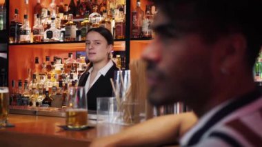 Genç bayan barmen, bira barında kutlama yapan üç çok ırklı arkadaşla konuşuyor.. 