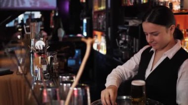 Genç bayan barmen bira servisi yapıyor. Bira barında kutlama yapan üç çok ırklı arkadaş.. 