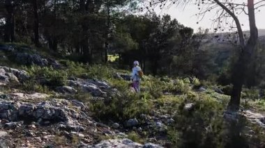 Beyaz kız çam ormanlarında dağ yolunda yürüyor. Çocuk gün batımında dışarıda yürüyüş yapmayı seviyor. Geniş açı